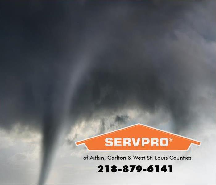 A tornado funnel is forming in a turbulent sky filled with dark clouds. 