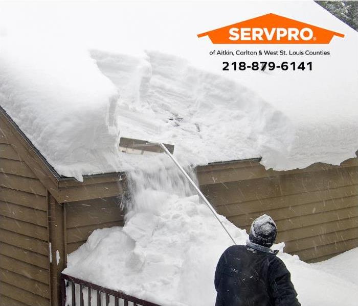 A person removes snow from their roof.